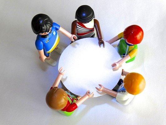 Playmobil-Figuren an einem Tisch in Besprechung